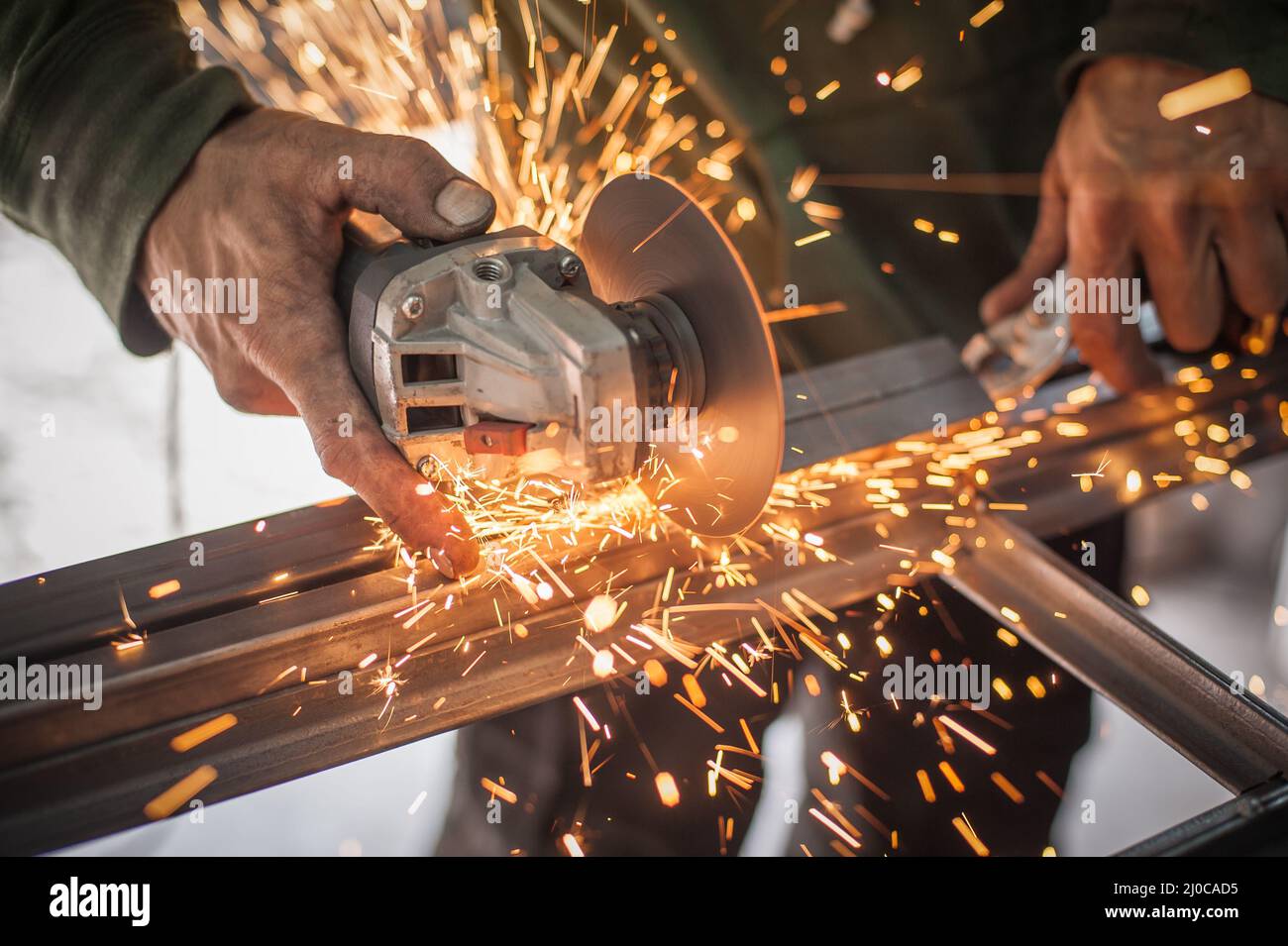 Electric wheel grinding on steel structure in factory. Sparks from the