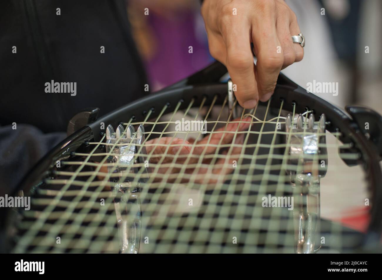 Stringing Machine. Close up of tennis stringer hands doing racket
