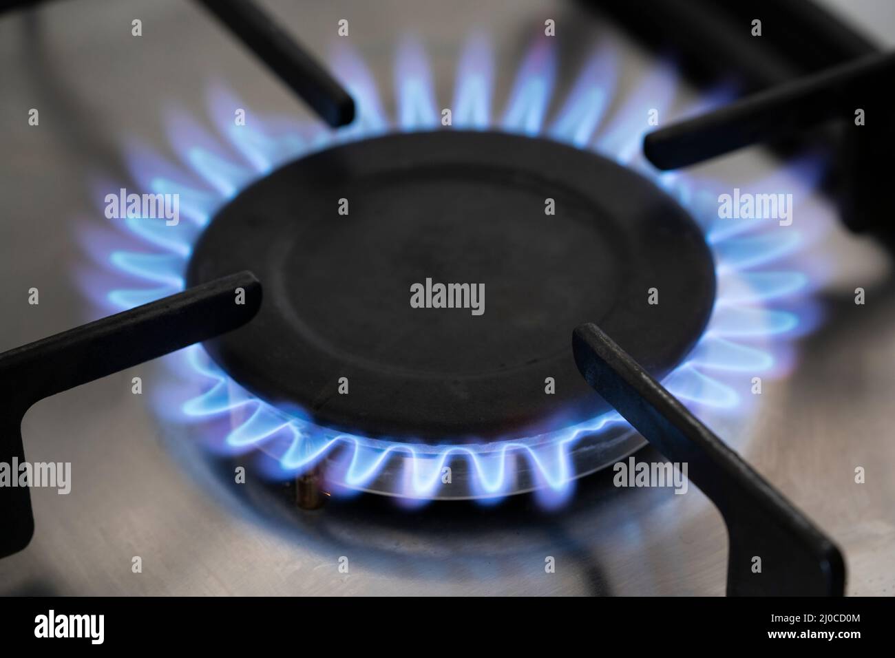 A blue flame on a natural gas cooker in England. Theme energy price cap, rising energy bills