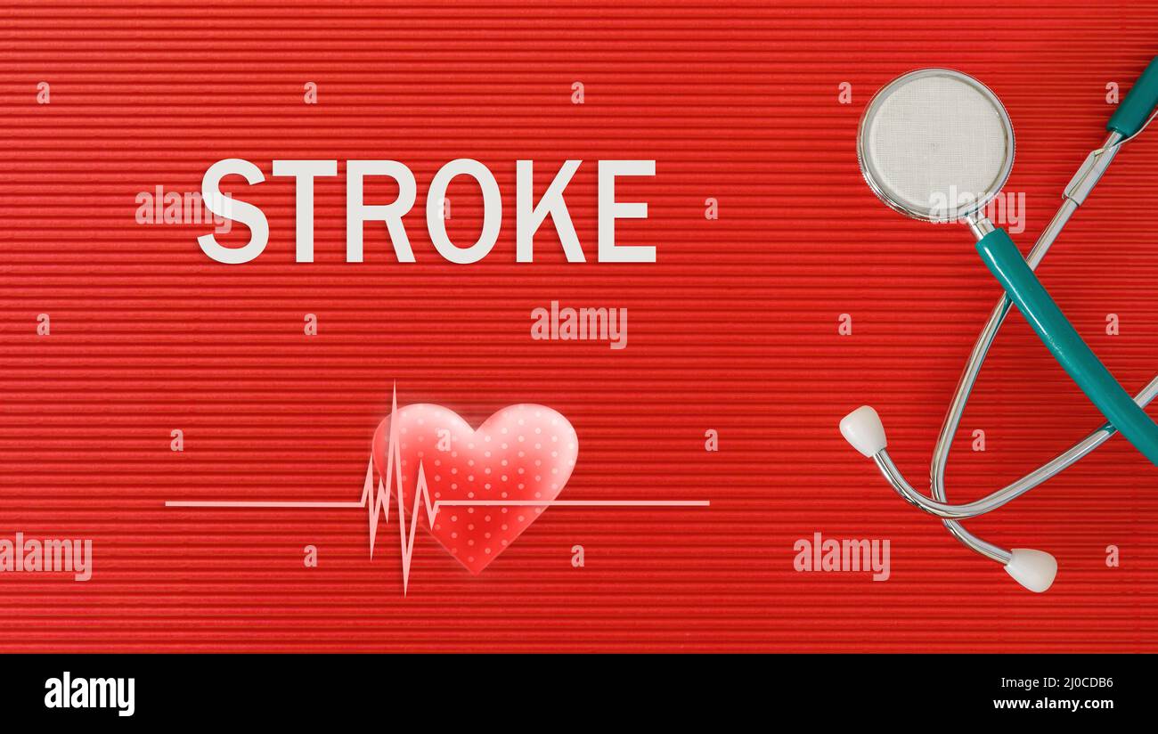 STROKE concept with stethoscope and heart shape on a red background Stock Photo