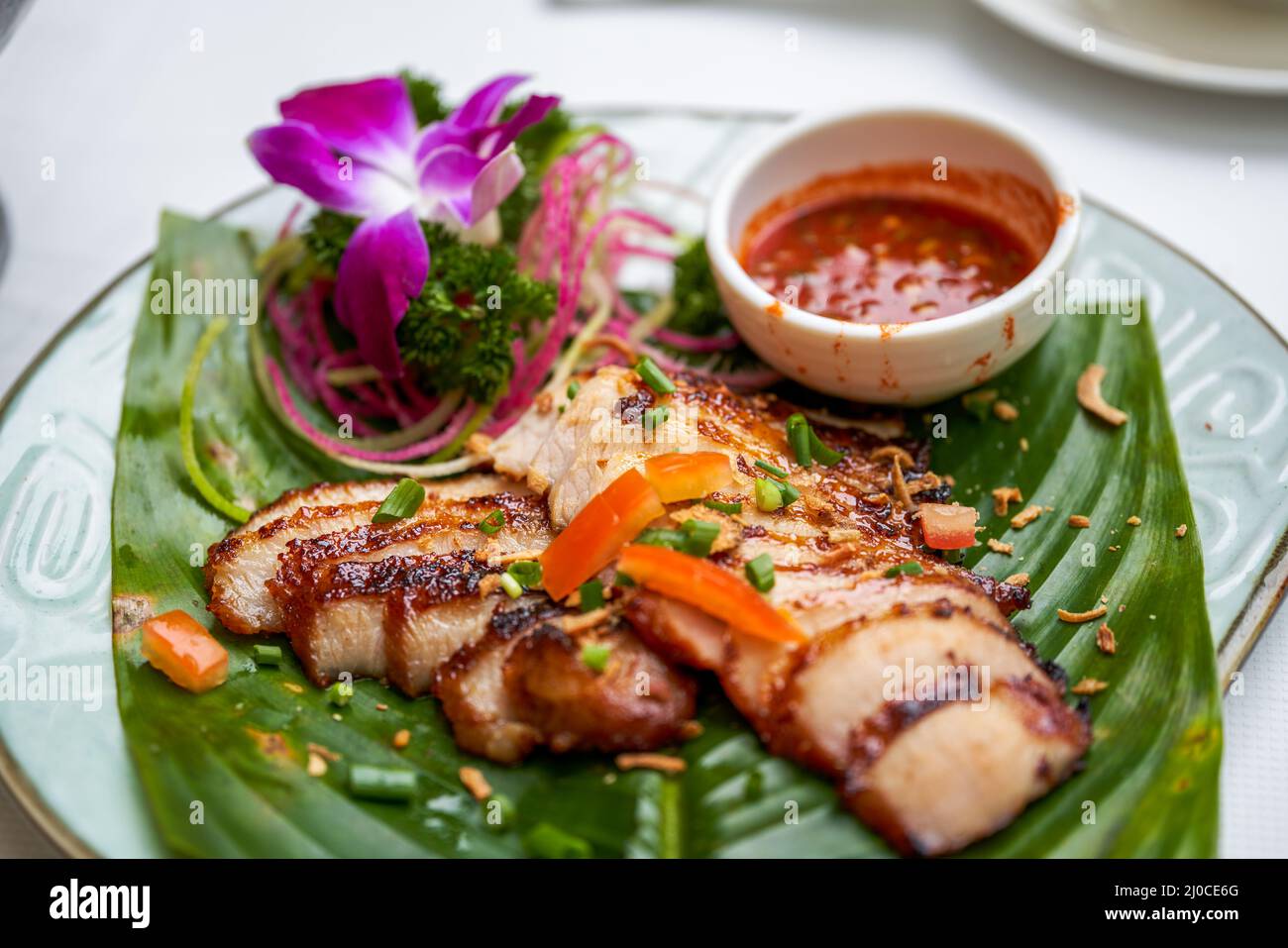 A plate of crispy and delicious roasted pork neck with Thai chutney Stock Photo