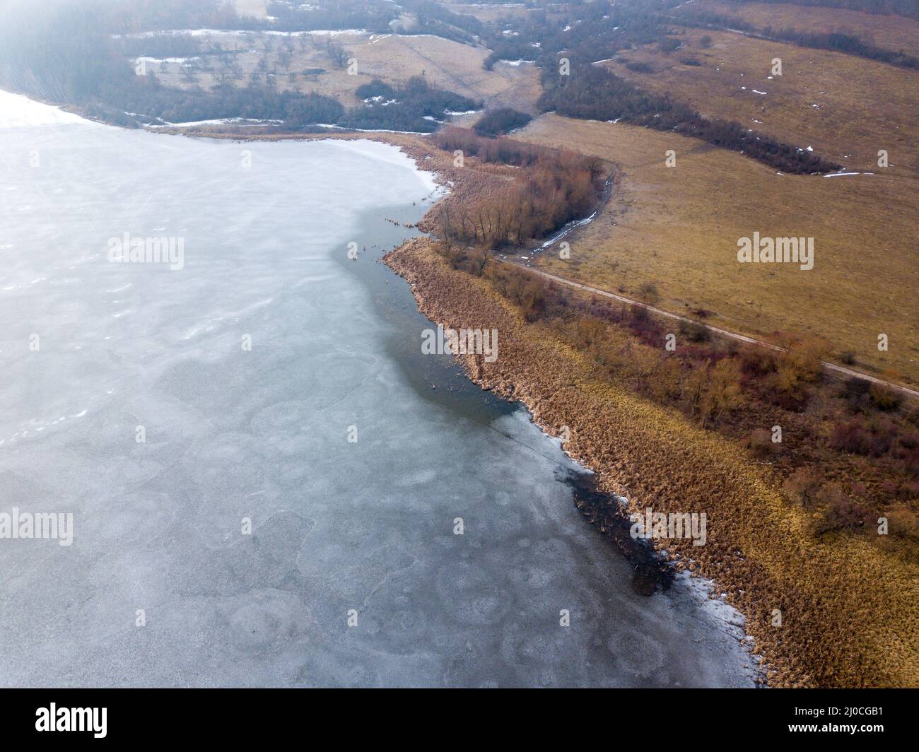 Bird's eye view of a frozen lake in the middle of a golden forest Stock ...