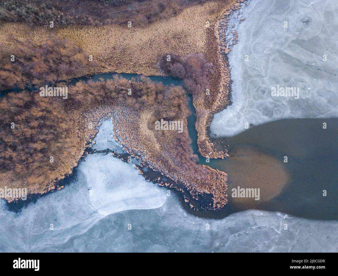 Bird's eye view of a frozen lake in the middle of a golden forest Stock ...