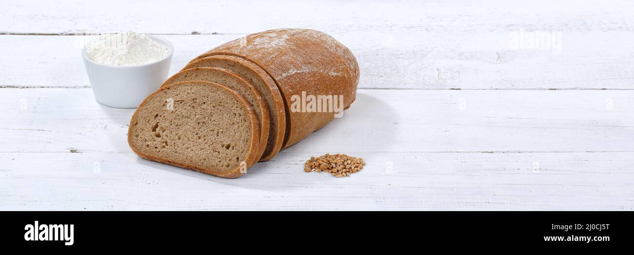 Bread wheat bread wheat mixed bread cut slice banner text free space on wooden plate Stock Photo