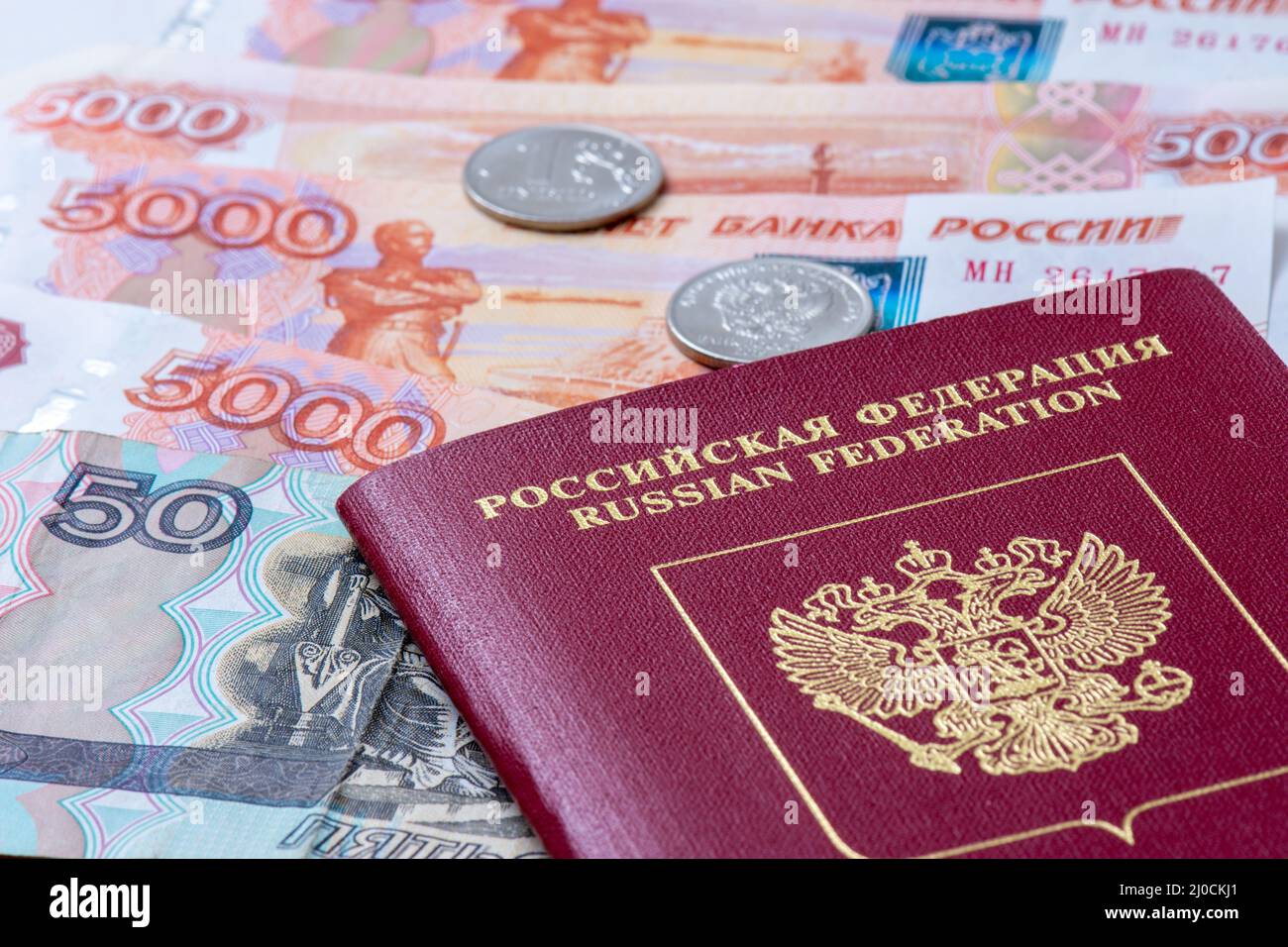Russian Federation passport and banknotes (rubles). Concepts of travel, economic sanctions, money transfers and inflation for citizens of Russia Stock Photo