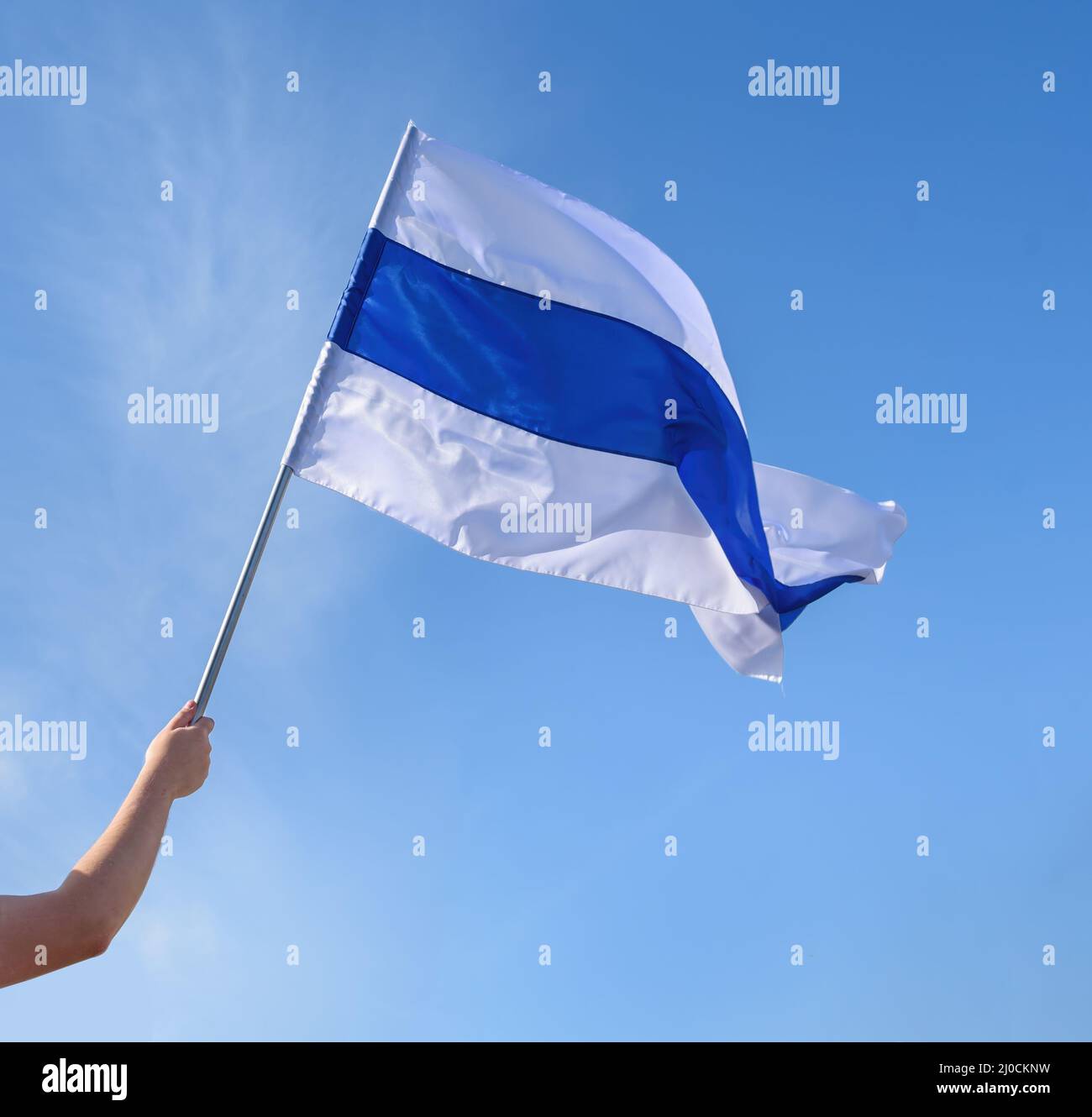Hand holding white-blue-white flag used by Russian anti-war protesters against the 2022 Russian invasion of Ukraine Stock Photo