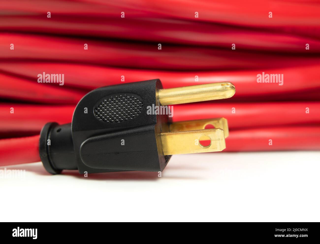 Power plug closeup with red extension cord background. Sideview of type B plug. Fits American standard NEMA 5-15 electrical sockets. Used in Canada, U Stock Photo