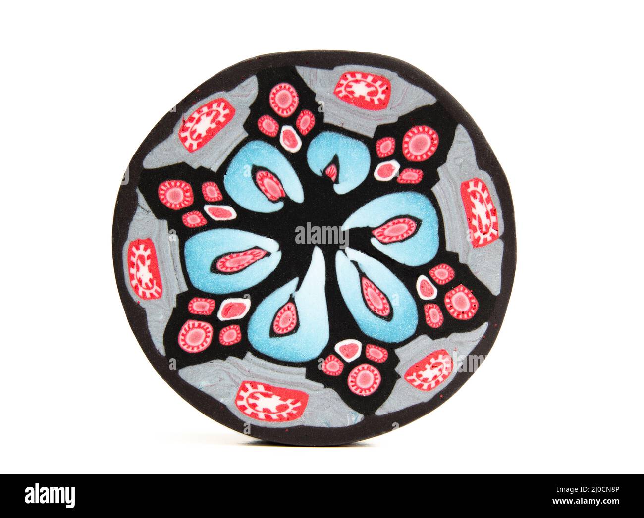 Millefiori cane slice or cross section. Colorful and intricate polymer clay cane. Blue, red and black floral designs, compressed and reduced. Artisan Stock Photo