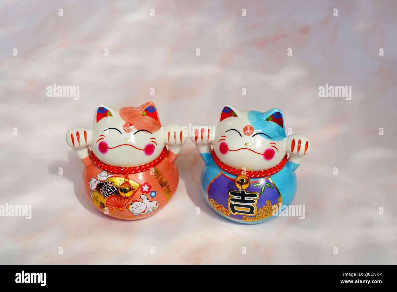 Japanese beckoning cats (maneki neko) made of porcelain. They are traditional symbols of good luck. Stock Photo