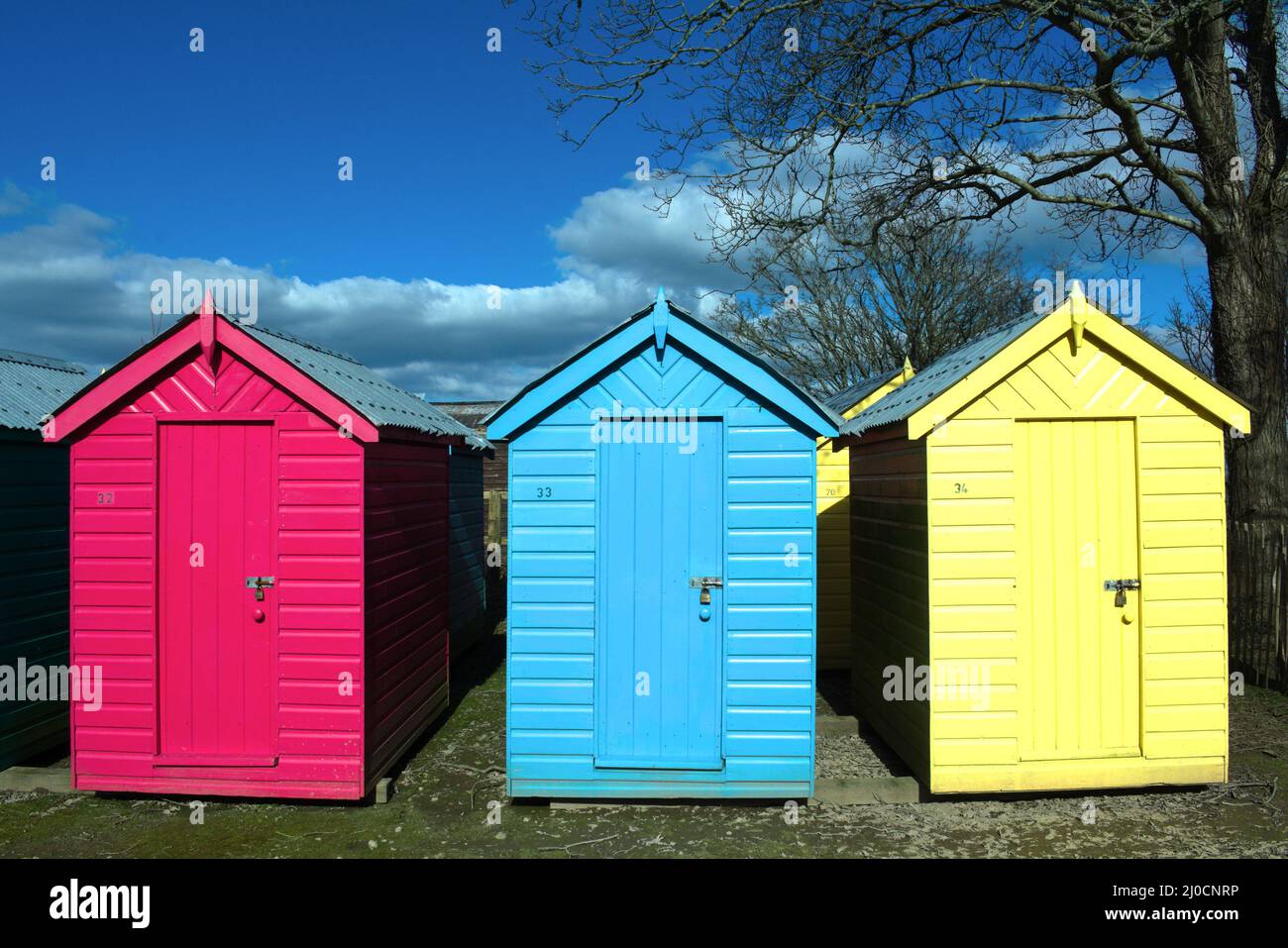 Traditional, old fashioned seaside beach huts. Typical British beach scene at Abersoch, north Wales on a sunny spring day. Close up view Stock Photo