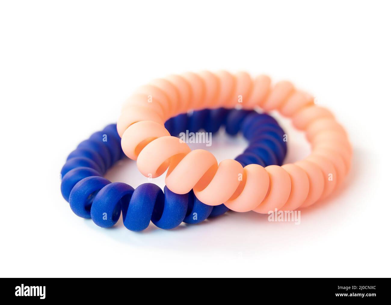 Two scrunchies isolated on white. Hair style product. Blue and soft pink spiral hair ties or phone cord hair ties. Used to tie hair in a ponytail with Stock Photo