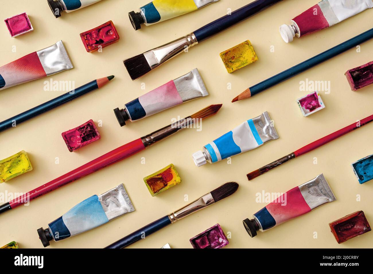 Tubes of paint with pencil crayons oi diagonal lines in an art themed