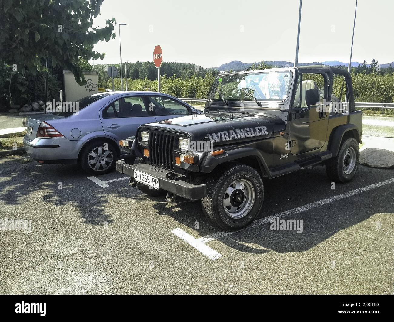 Closeup of Classic and typical off road SUV, model of '90s Jeep Wrangler in  the parking spot Stock Photo - Alamy