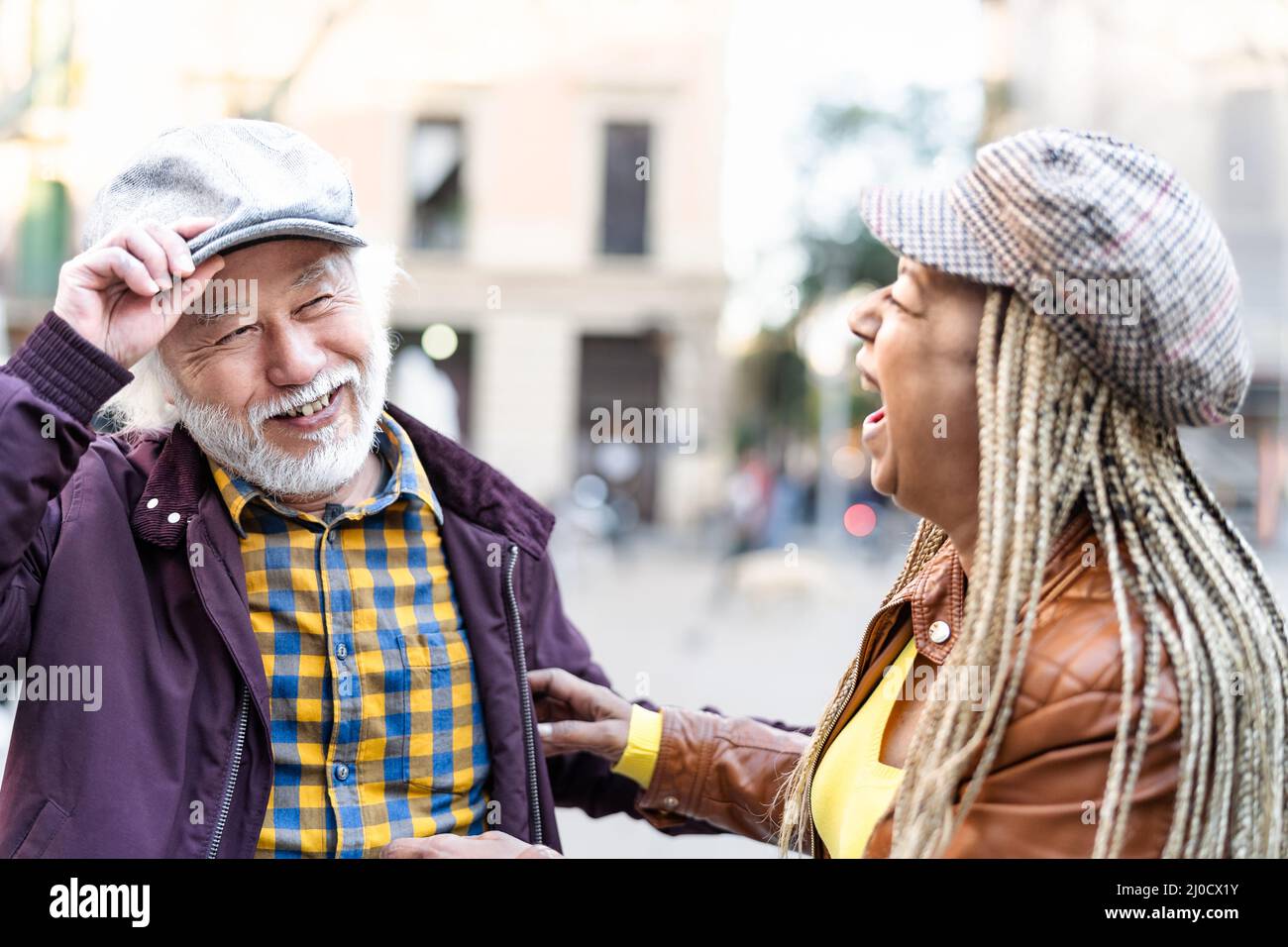 Happy multiracial senior couple having fun in city - Elderly people and love relationship concept Stock Photo