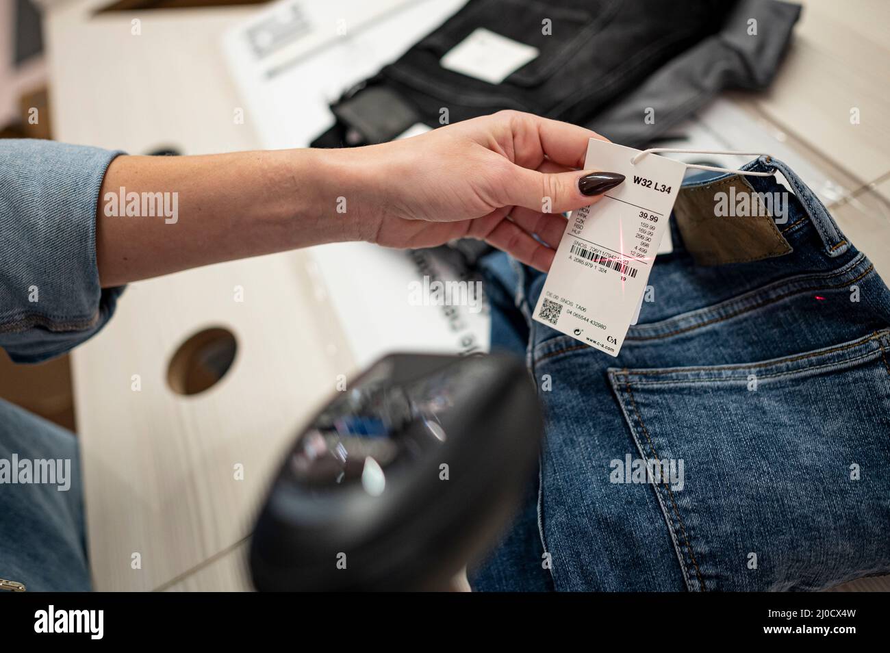 Berlin, Germany. 02nd Mar, 2022. An employee scans several pairs of jeans  at the C&A clothing store in a shopping center in Berlin-Marzahn. Credit:  Fabian Sommer/dpa/Alamy Live News Stock Photo - Alamy