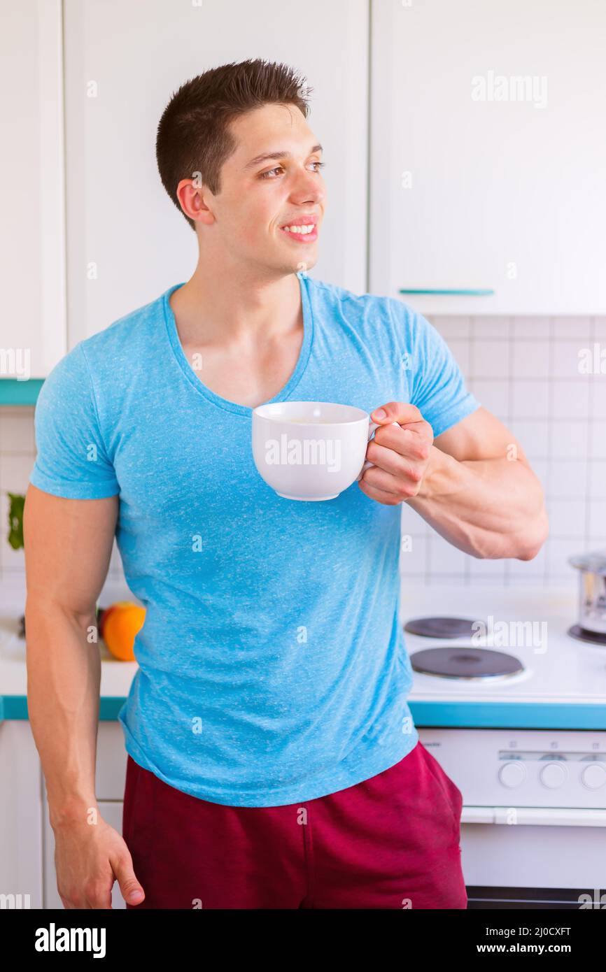 Young man drinking drinking coffee in kitchen portrait morning Stock Photo