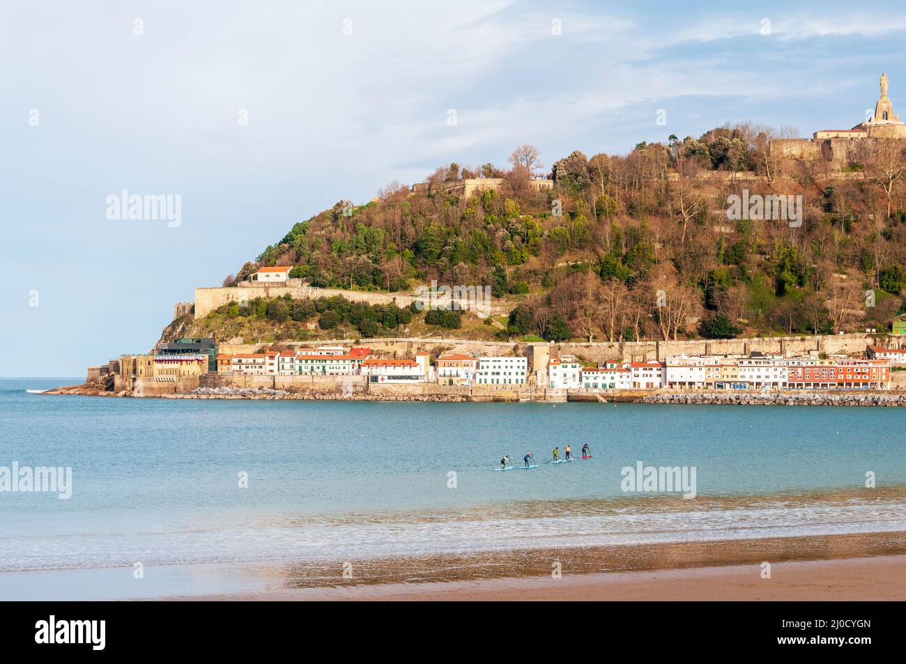 Paddle boarders in Bahia de La Concha, San Sebastian with views of the old town and medieval castle on the hill Stock Photo