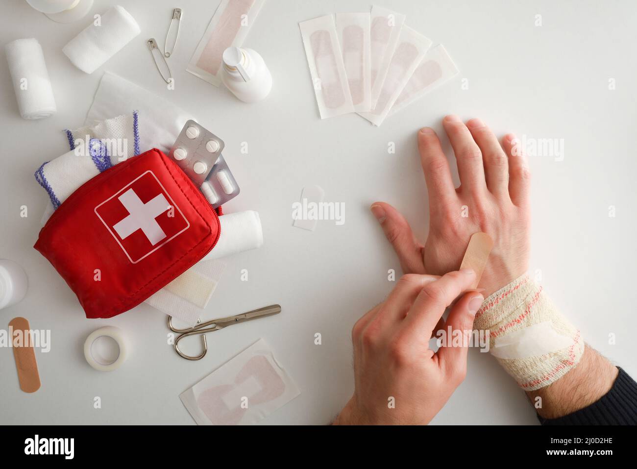 Home cures service with a hand curing another on a white table full of basic equipment for cures. Horizontal composition. Top view. Stock Photo