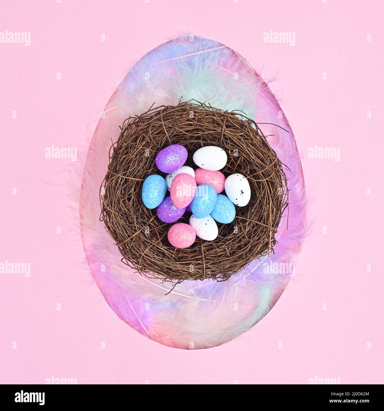 Egg shape with neast with eggs on pastel pink background. Flat lay creative Easter concept Stock Photo