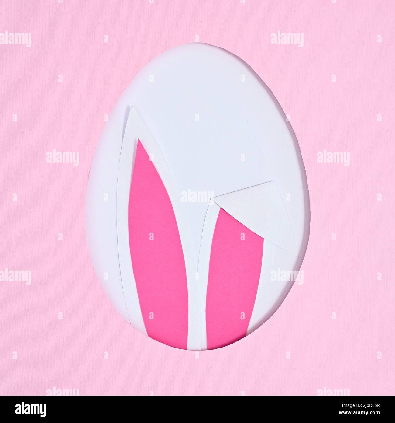 Easter creative concept. Egg shape with bunny ears on pastel pink background. Flat lay Stock Photo