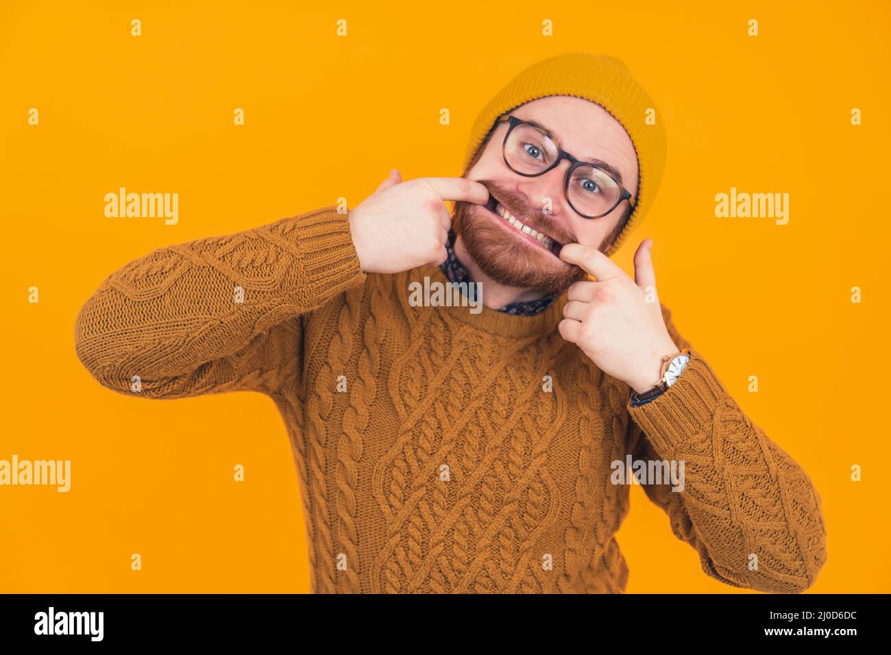 young caucasian man making a goofy face by widening his face with his own fingers. High quality photo Stock Photo
