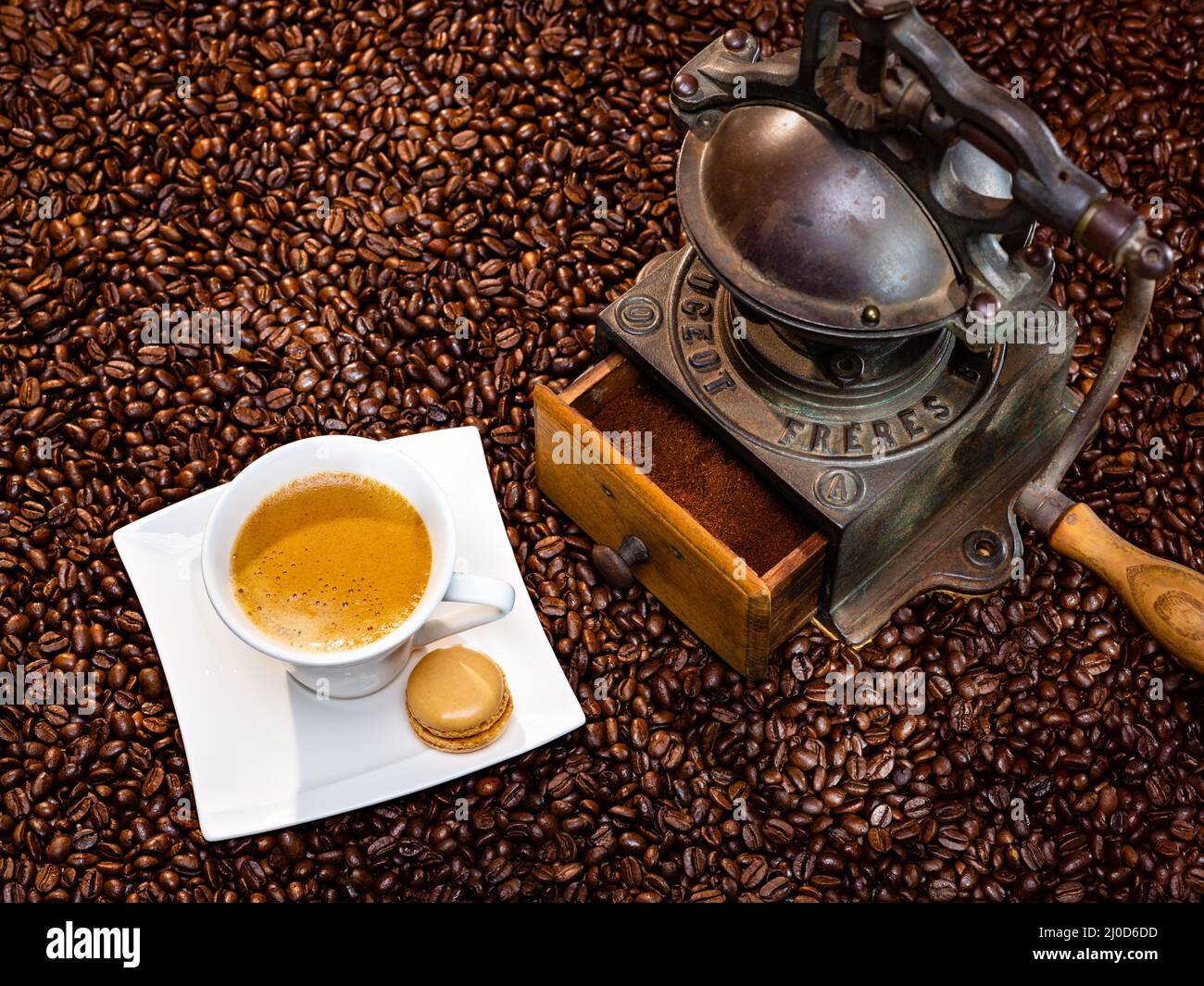 Fresh cup of coffee, roasted beans and antique grinder Stock Photo