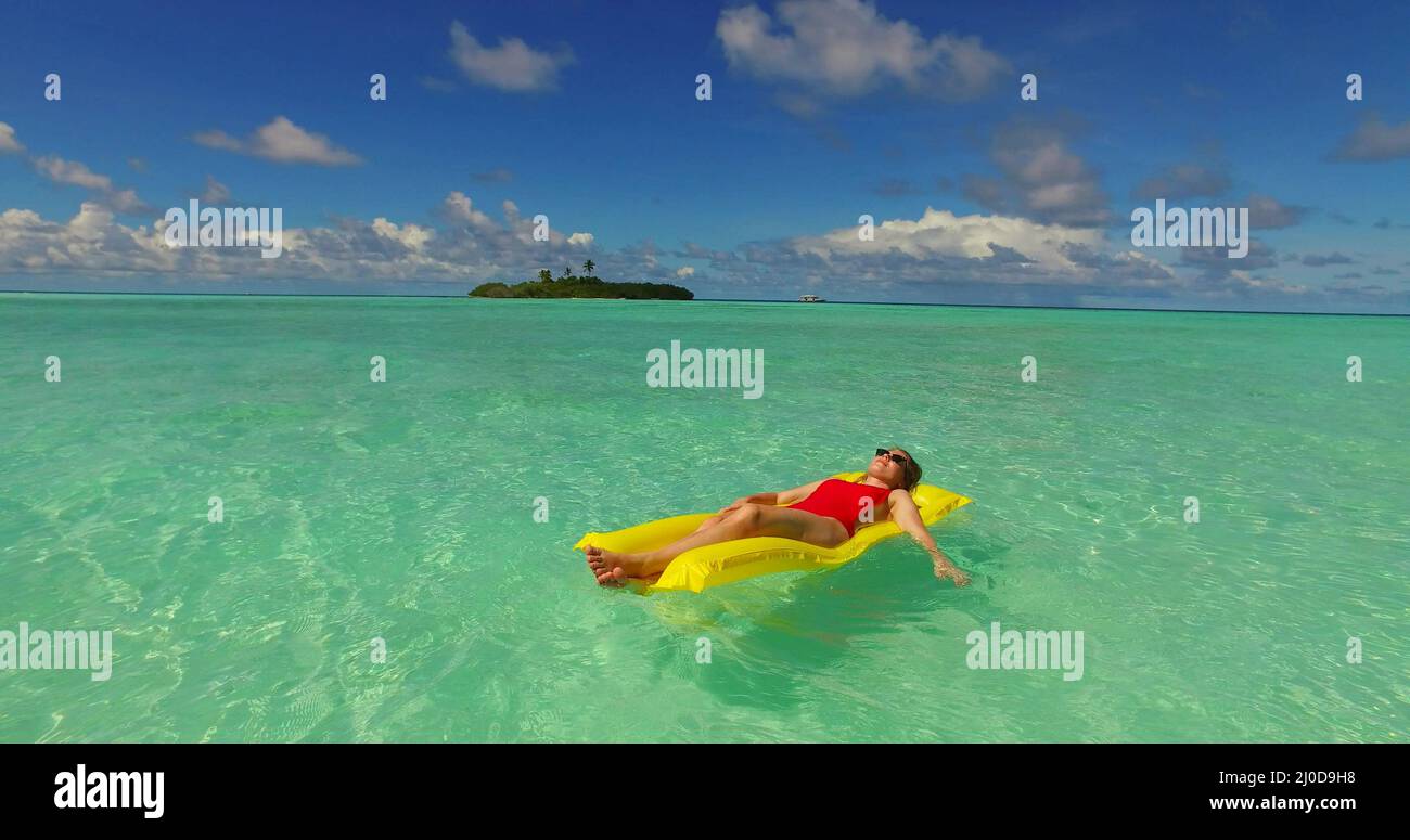 Young female relaxing on a floatie on the water near Rasdhoo Island, the Maldives Stock Photo