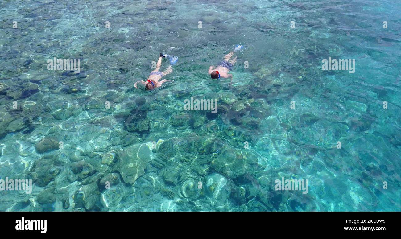 Aerial view of a young couple scuba diving near Rasdhoo Island, the