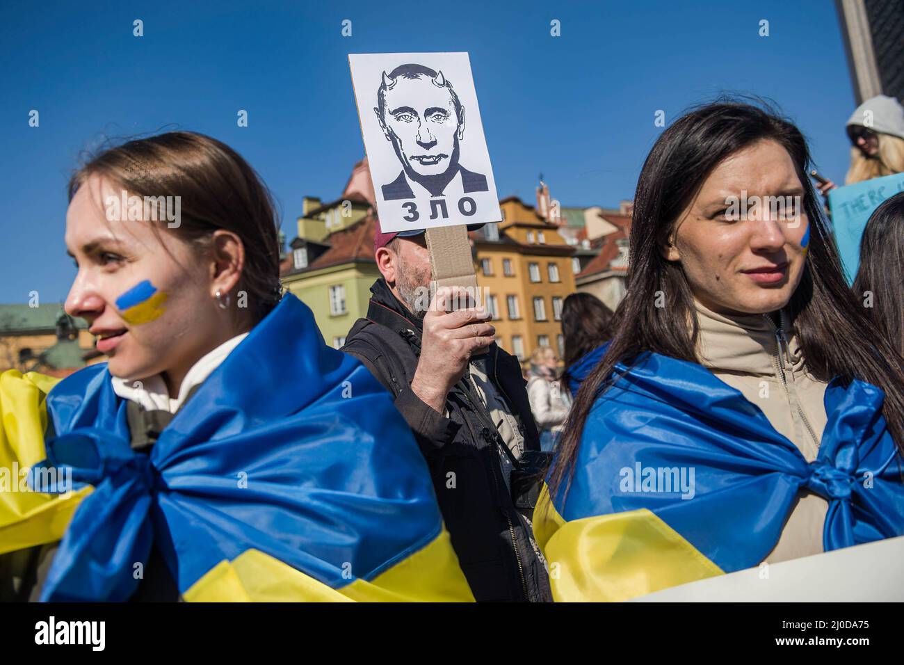 Warsaw, Poland. 18th Mar, 2022. A Ukrainian man holds a placard saying  "Evil' under the image of Vladimir Putin" during the protest. The "March of  Ukrainian Mothers" was held in Warsaw, which