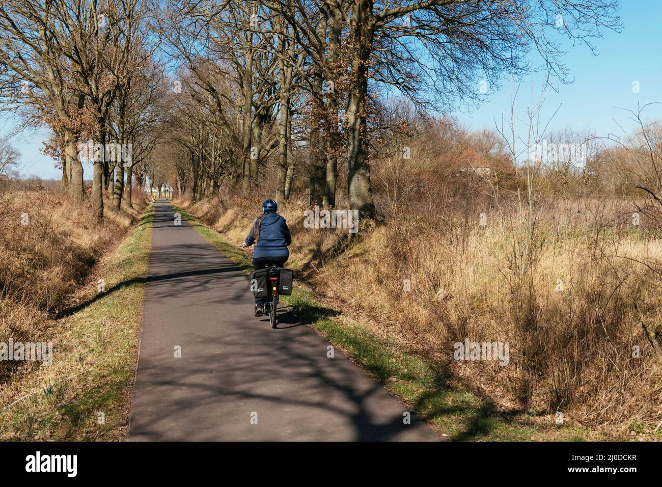 Woman on an e-bike biking on the Weser cycling route near Petershagen. Stock Photo
