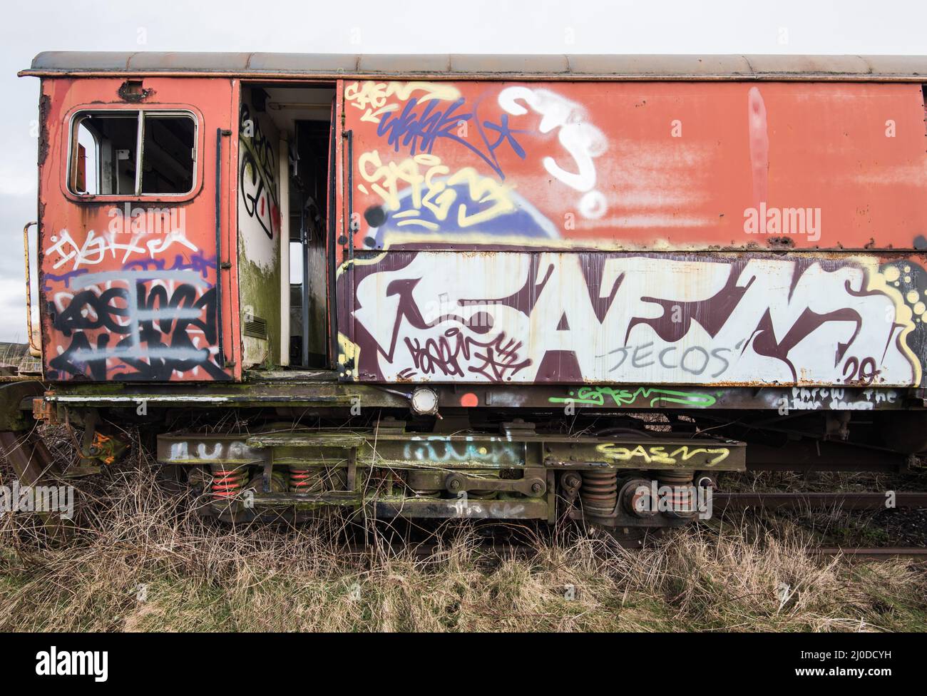 Graffiti vandals spray painted graffiti on abandoned railway carriages Stock Photo