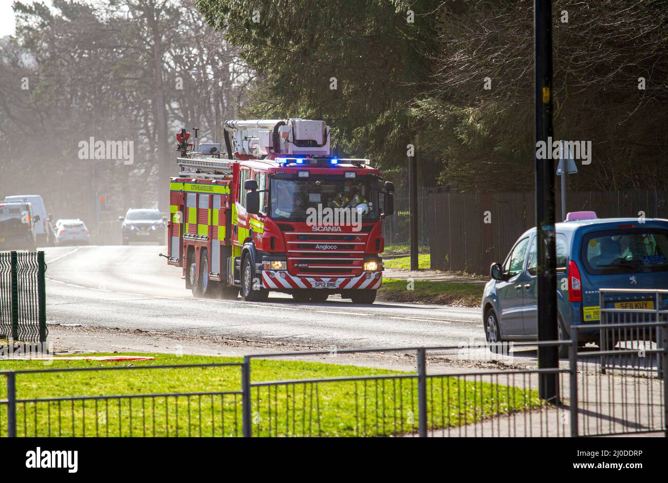 A Scottish Fire and Rescue Service fire engine responds at high speed to an emergency 999 call along MacAlpine Road in Ardler, Dundee, Sotland Stock Photo
