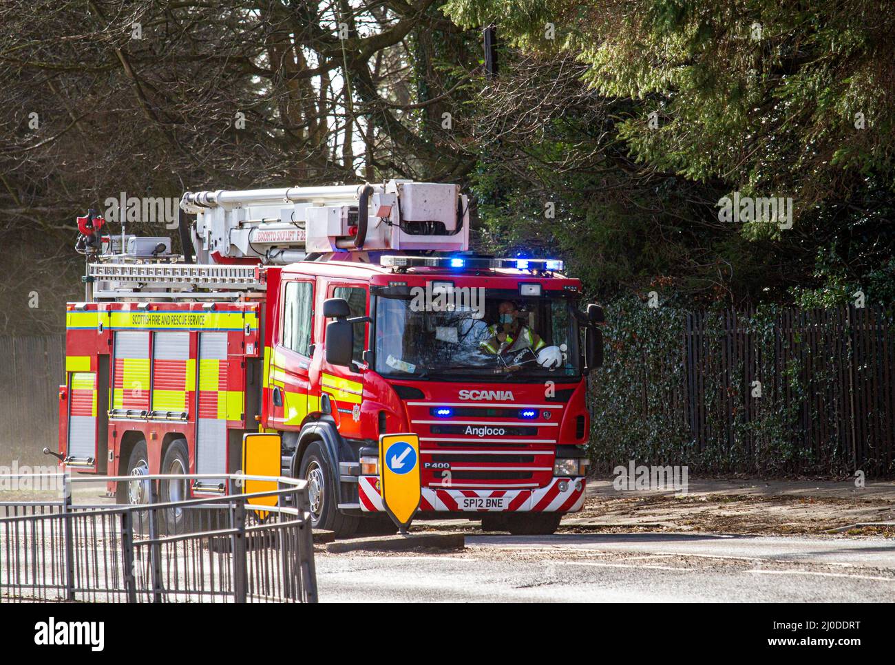 A Scottish Fire and Rescue Service fire engine responds at high speed to an emergency 999 call along MacAlpine Road in Ardler, Dundee, Scotland Stock Photo