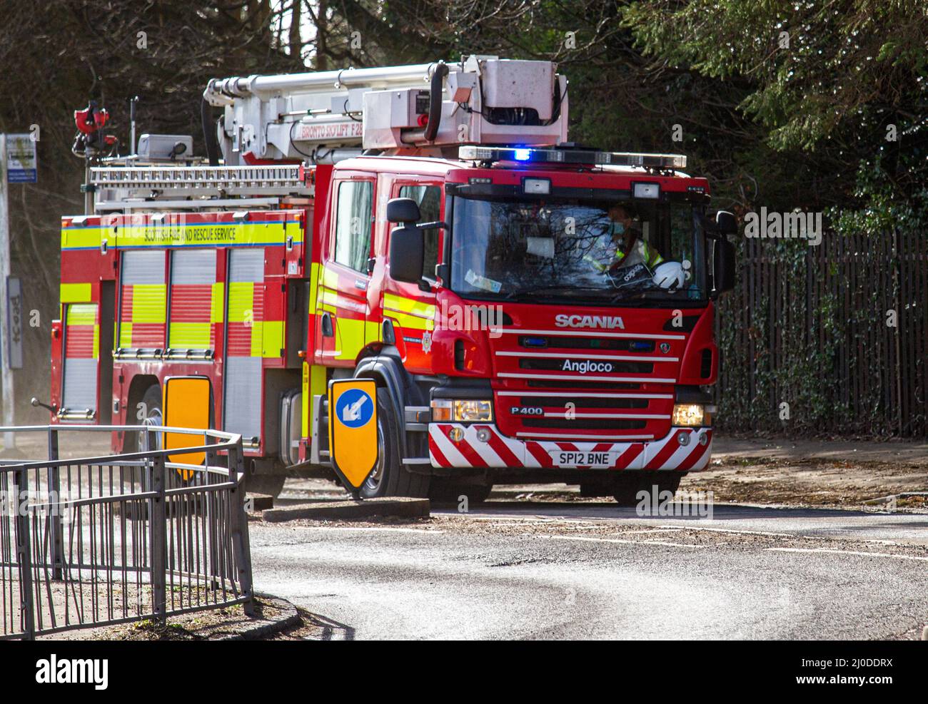 A Scottish Fire and Rescue Service fire engine responds at high speed to an emergency 999 call along MacAlpine Road in Ardler, Dundee, Scotland. Stock Photo