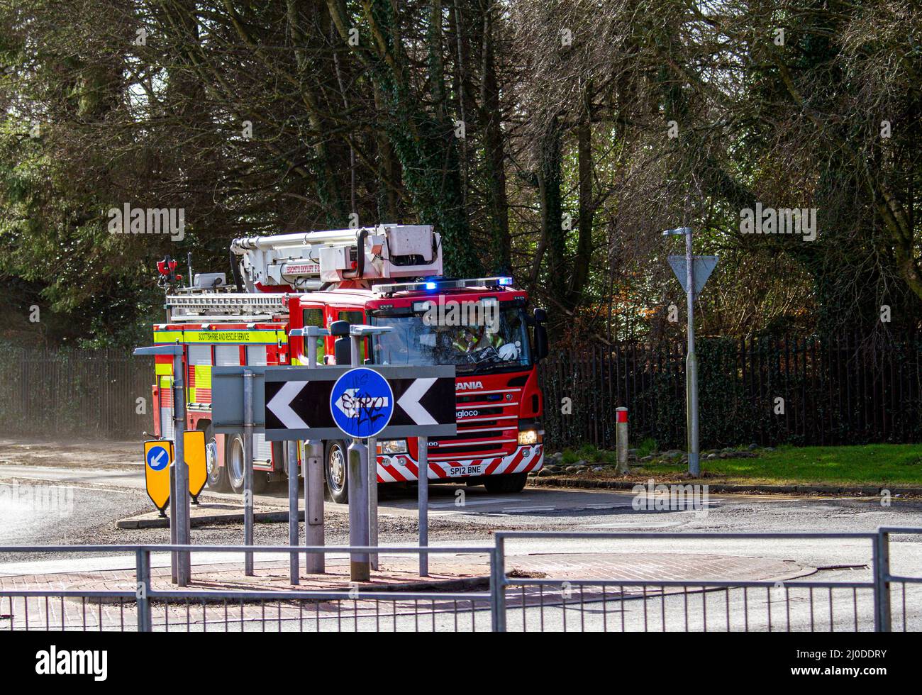 A Scottish Fire and Rescue Service fire engine responds at high speed to an emergency 999 call along MacAlpine Road in Ardler, Dundee, Scotland Stock Photo