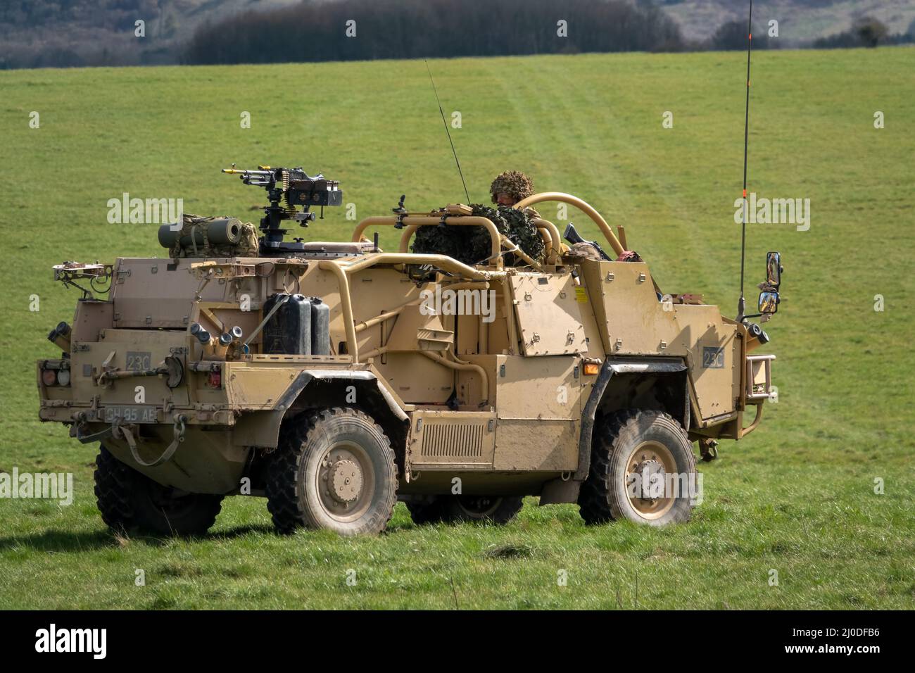 British army Supacat Jackal rapid assault, fire support and reconnaissance vehicle in action on a military training battle exercise, blue sky cloud Stock Photo