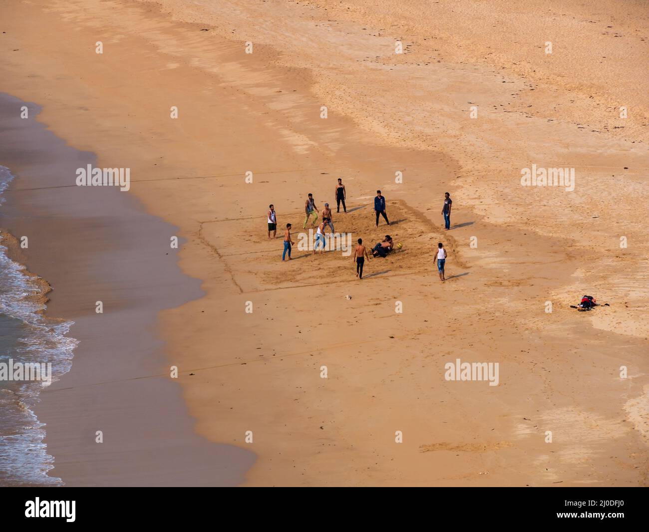 Sindhudurg, India - December  21, 2021 : Unidentified indian guys playing beach volleyball at neat and clean Devgadh beach. Stock Photo