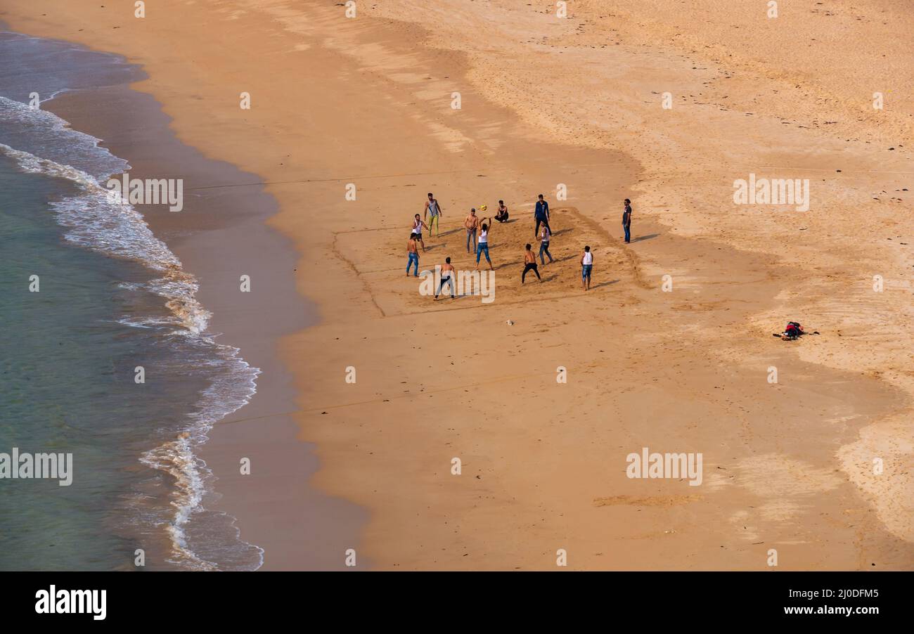 Sindhudurg, India - December  21, 2021 : Unidentified indian guys playing beach volleyball at neat and clean Devgadh beach. Stock Photo