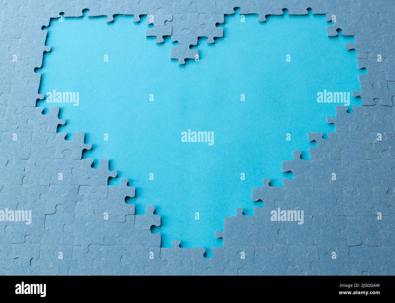 Heart shaped on blue background. Jigsaw puzzle pieces. Space for text. Copy space Stock Photo