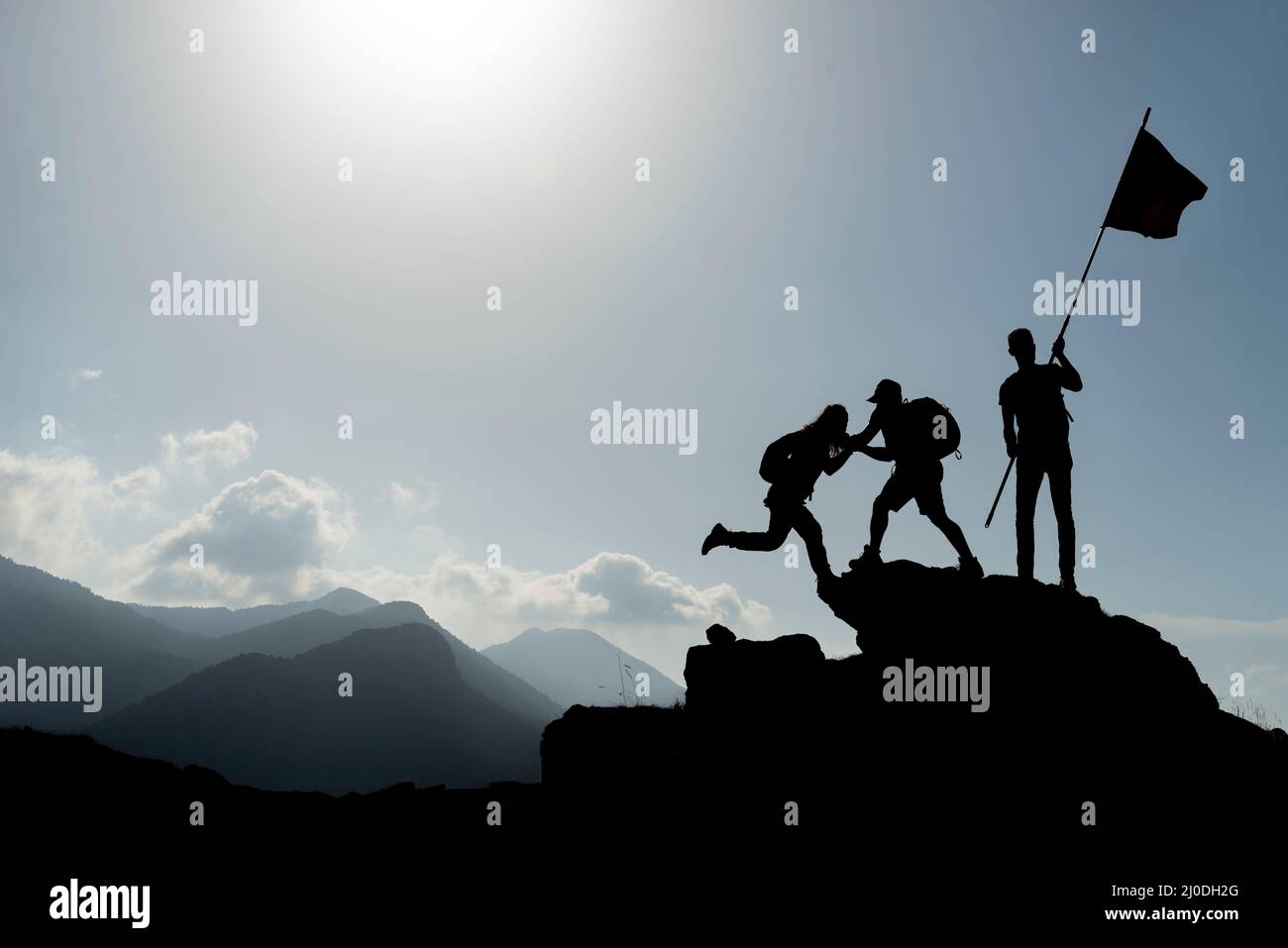 mountaineering activities,success at the summit,assistance and flag Stock Photo