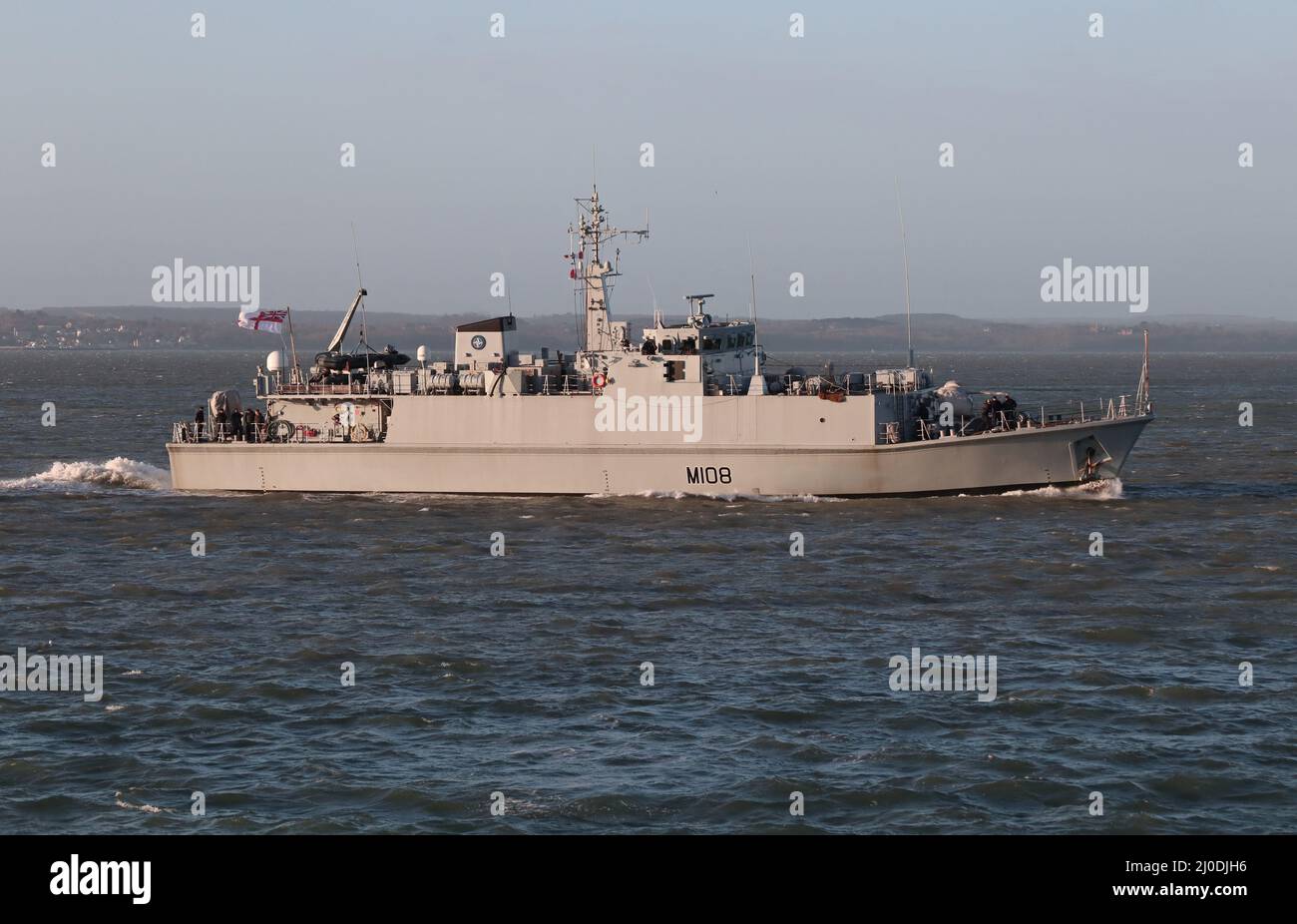 The Sandown class minehunter HMS GRIMSBY arrives at the Naval Base in early morning sunshine Stock Photo