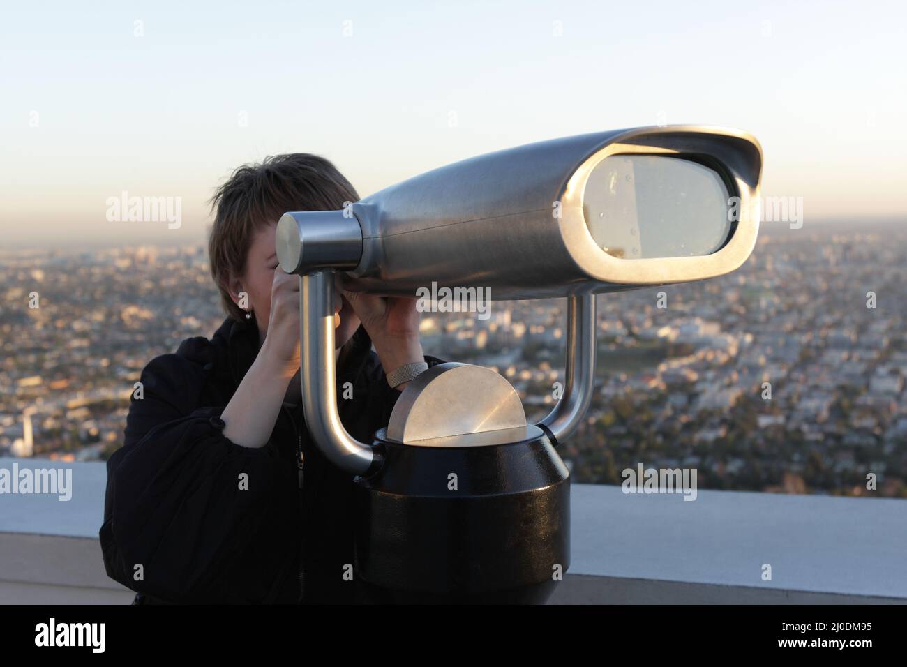 The woman looks through the binoculars on Los Angeles, USA Stock Photo