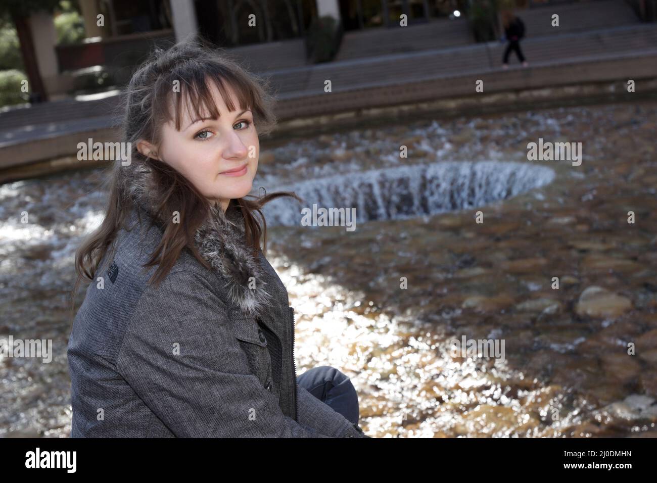 The girl poses on a fountain background Stock Photo - Alamy