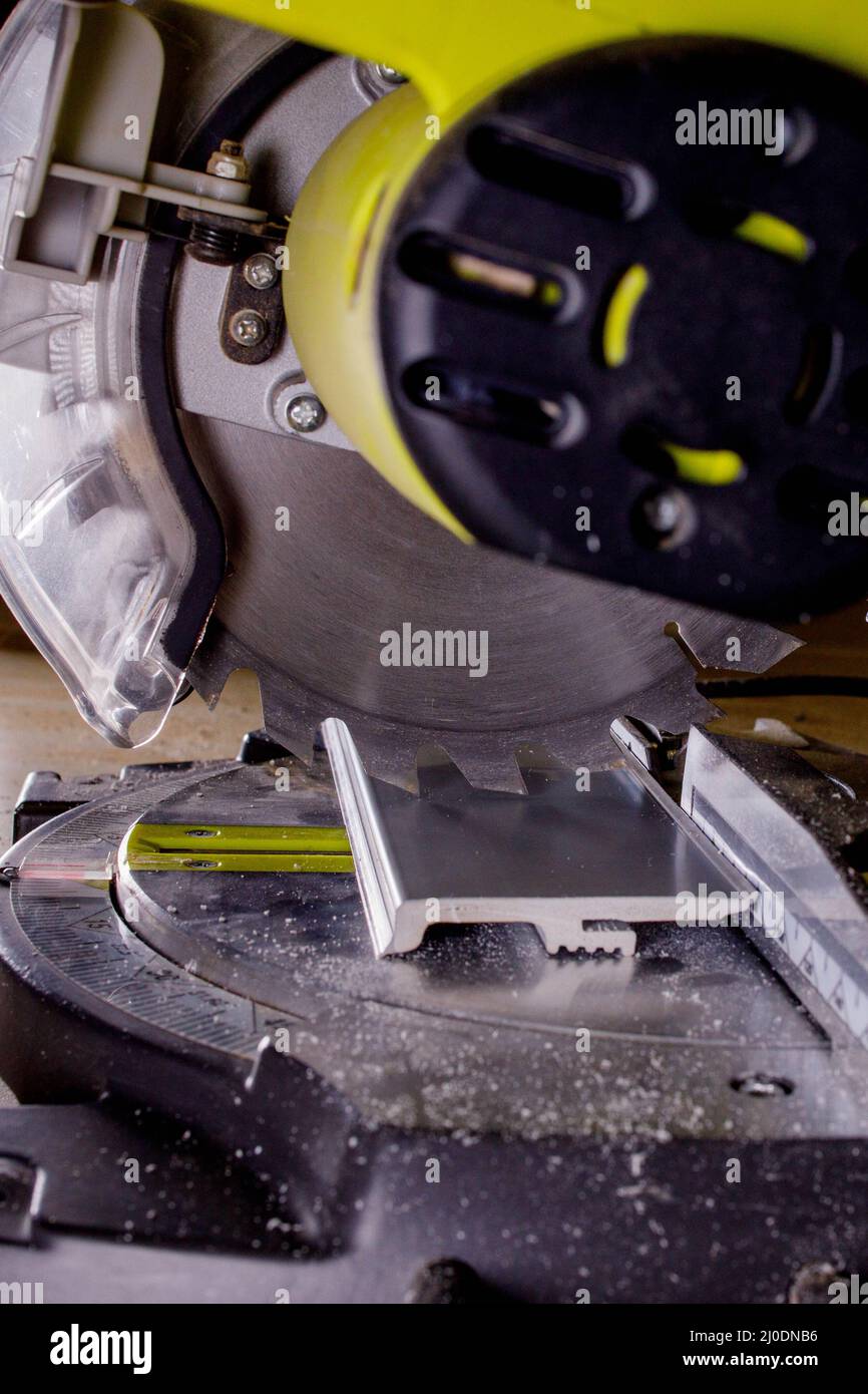 Worker cutting baseboard on the circular saw before installing Stock