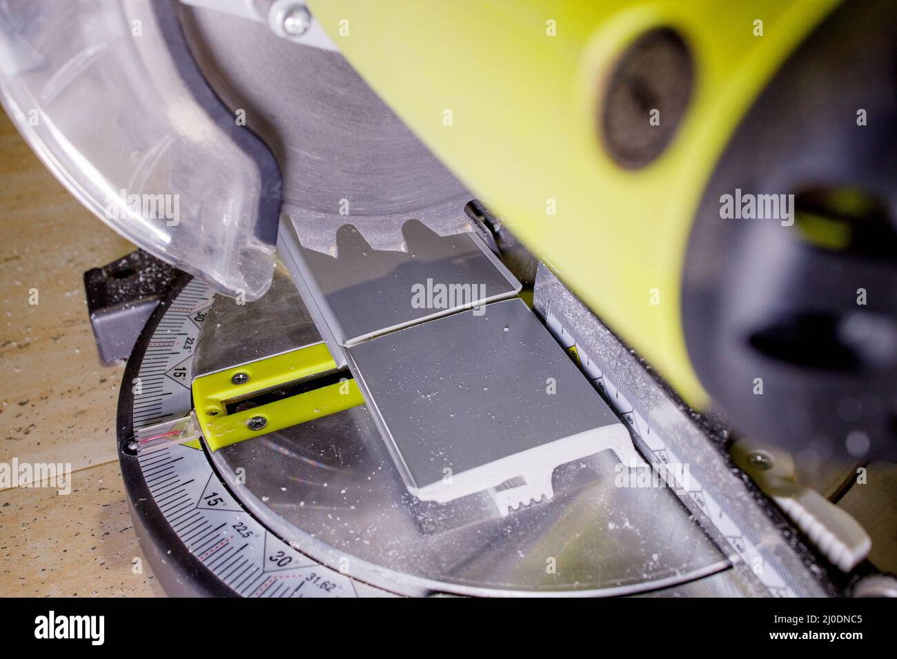 Worker cutting baseboard on the circular saw before installing Stock