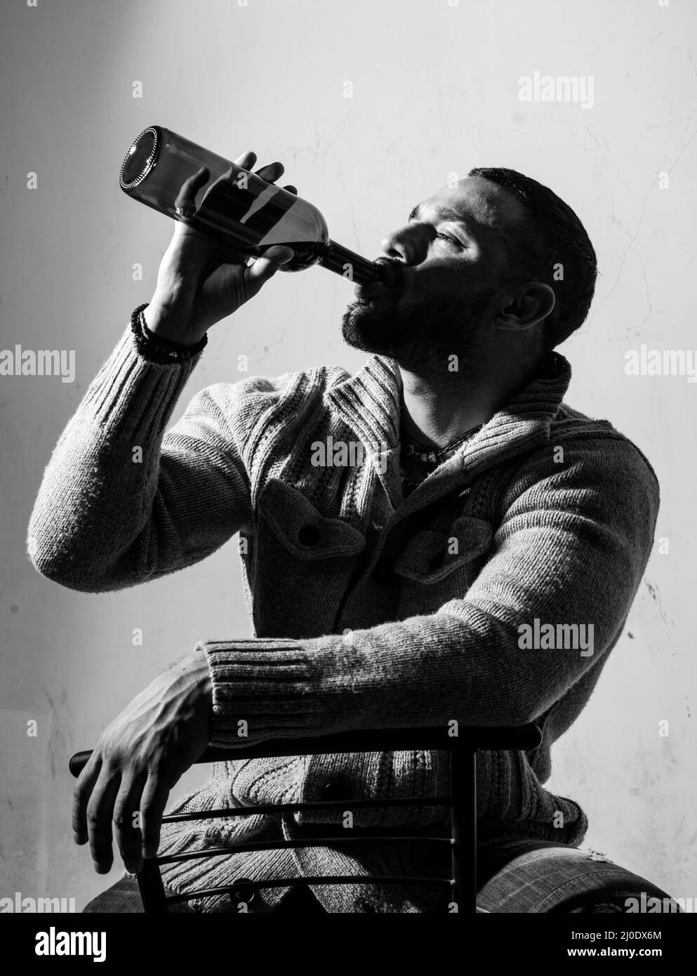 Drunk man drinking wine. Depressed guy with bottle alcohol. Abuse in