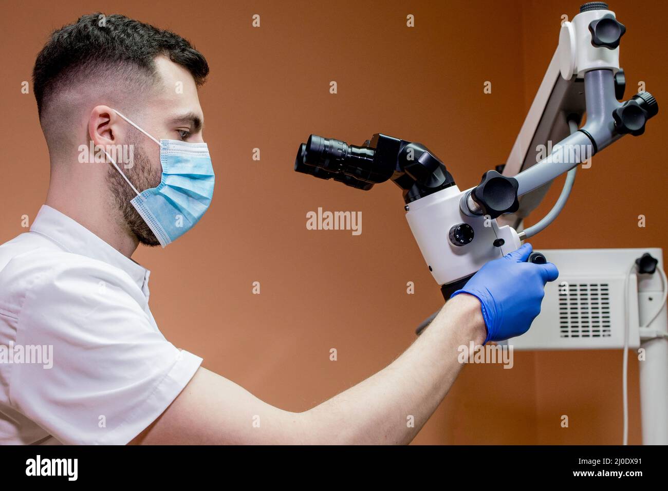 A young scientist conducting research with a microscope. Working with a