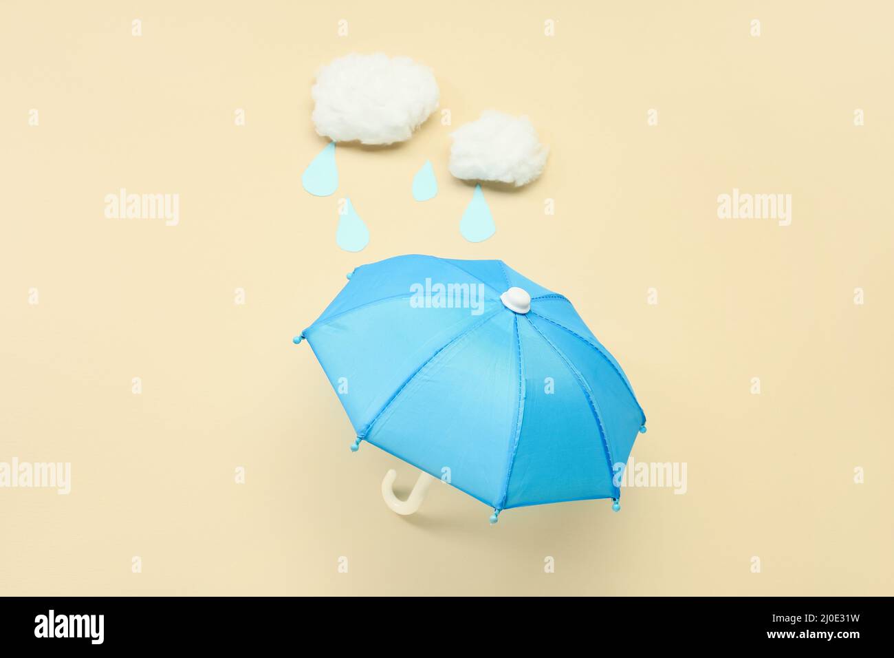 Composition with mini umbrella and cotton clouds on color background Stock Photo