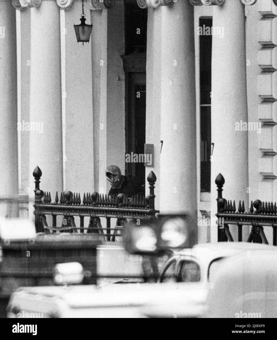 Third day of the Iranian Embassy Siege in London where six gunmen of the Iranian extremist group 'Democratic Revolutionary Movement for the Liberation of Arabistan' stormed the building, taking 26 hostages before the SAS retook the embassy and freed the hostages. Pistol in hand, one of the hood Arab terrorists steps out from the Embassy, lured out by lunch boxes of food placed on the doorstep by police for the gunmen and their hostages. 2nd May 1980. Stock Photo