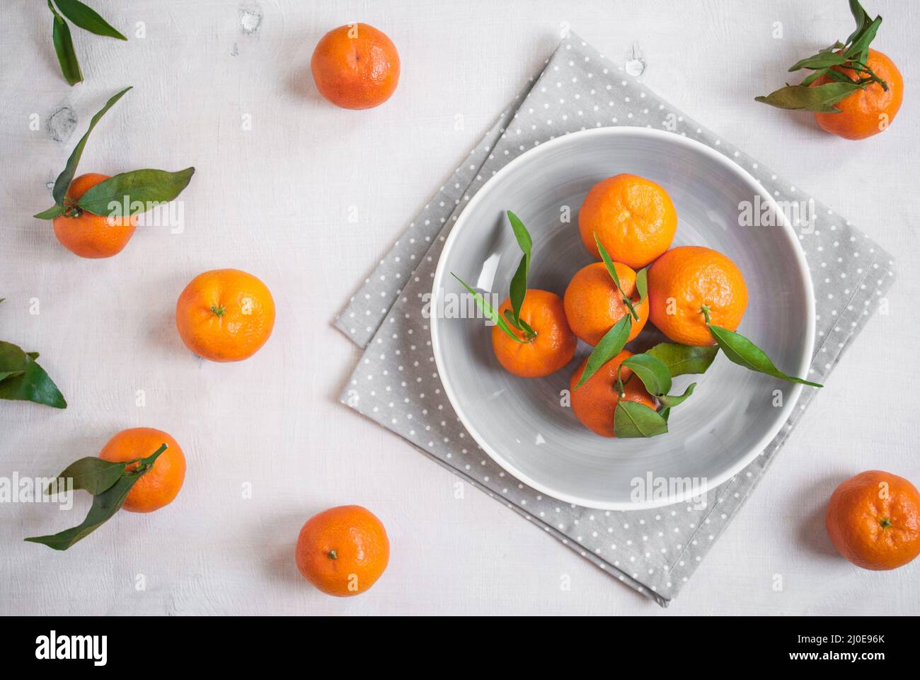 Tangerines on white wooden background. Grey polka dot fabric Stock Photo